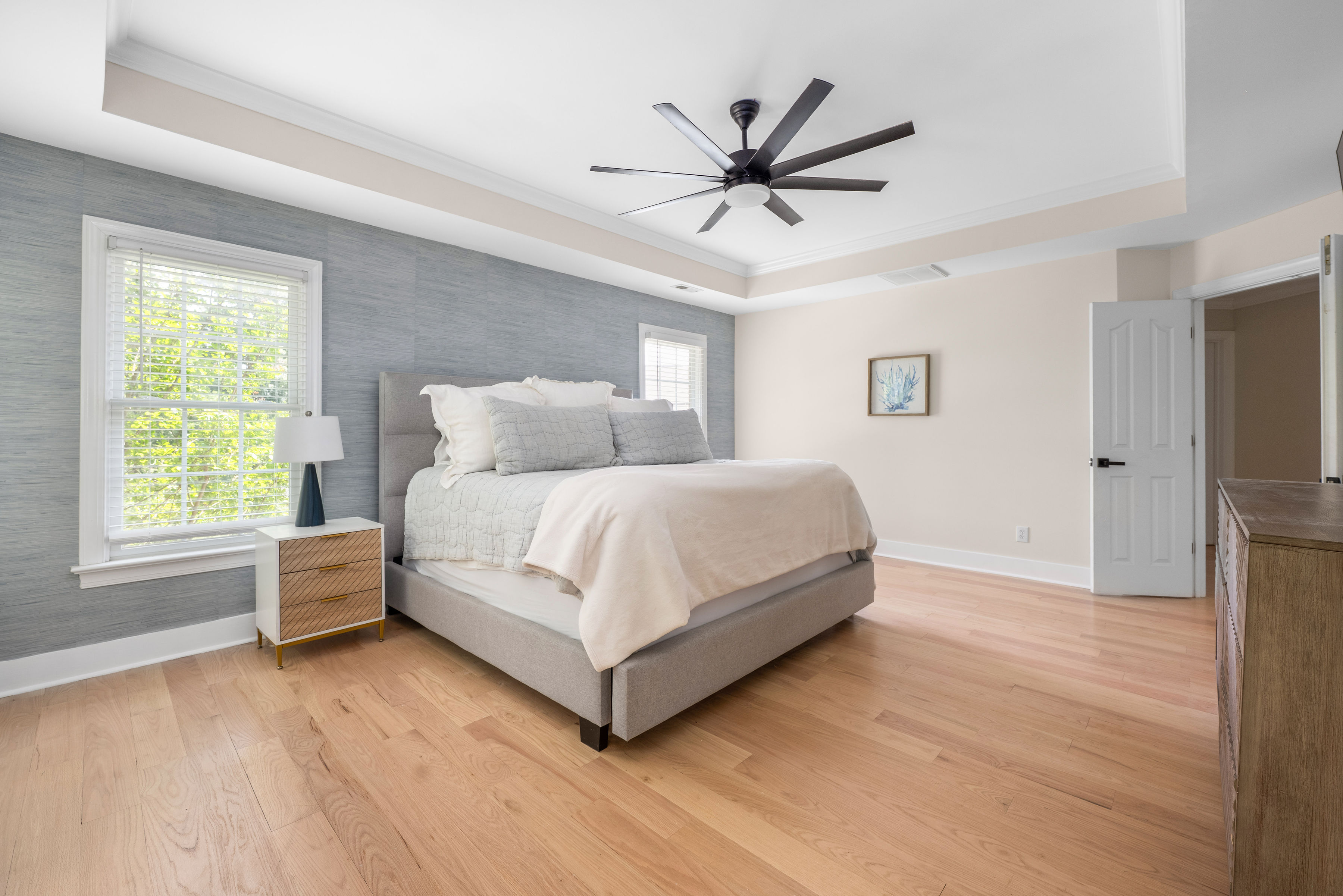 Spacious primary bedroom with elegant tray ceiling.