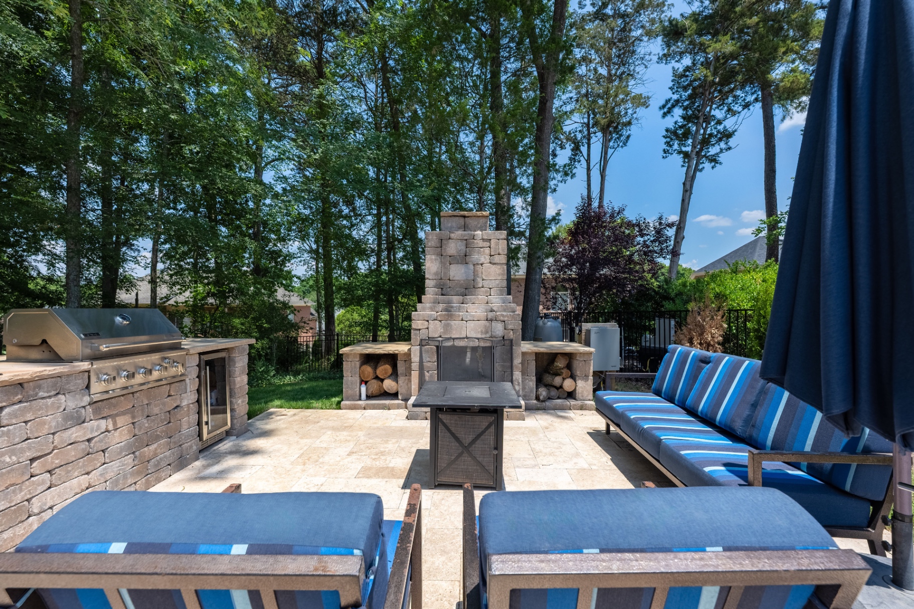 Outdoor kitchen and fireplace viewed from the terrace seating area.